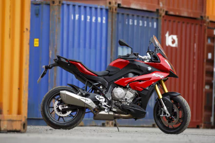A red BMW S1000 XR motorcycle parked in front of stacked shipping containers, captured in 4K Ultra HD as a striking PC desktop wallpaper.
