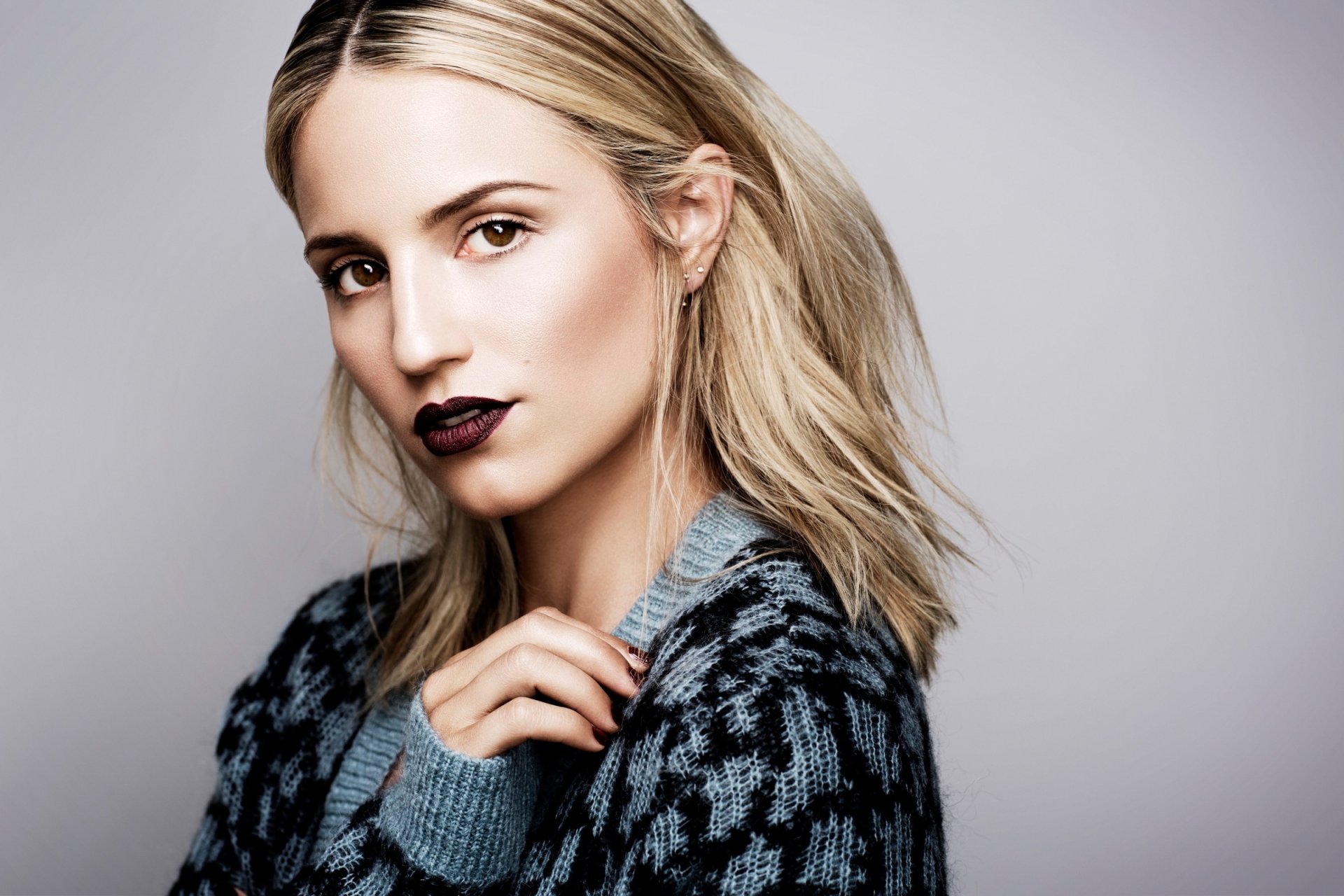 HD wallpaper of American actress Dianna Agron with blonde hair, hazel eyes, and dark lipstick, posing against a neutral background.