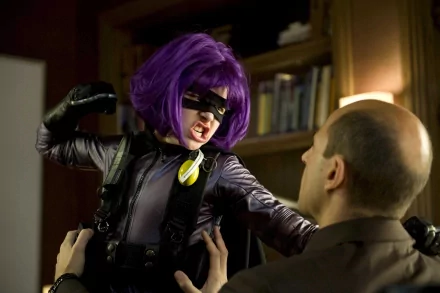 A scene from the movie Kick-Ass, featuring a character with purple hair in a combat pose, confronting another figure in a dramatic setting. HD wallpaper capture evokes action and intensity.