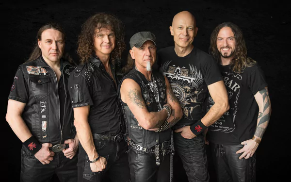 HD PC desktop wallpaper: five-member heavy metal band in leather and black tees posing against a dark background, exuding a high-energy rock music vibe.