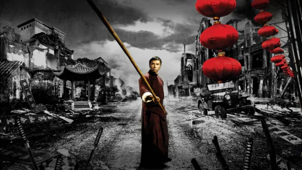 HD PC desktop wallpaper/background from the Ip Man movie: lone martial artist in robes holding a staff on a ruined street, bright red lanterns against a grayscale cityscape.