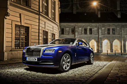 A blue Rolls-Royce Wraith parked on a cobblestone street at night, showcased as an HD PC desktop wallpaper and background.