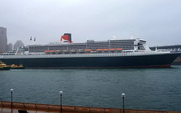 RMS Queen Mary 2 cruise ship docked at Sydney Harbour, Australia, captured as an HD desktop wallpaper showcasing the ocean liner against a cloudy sky.