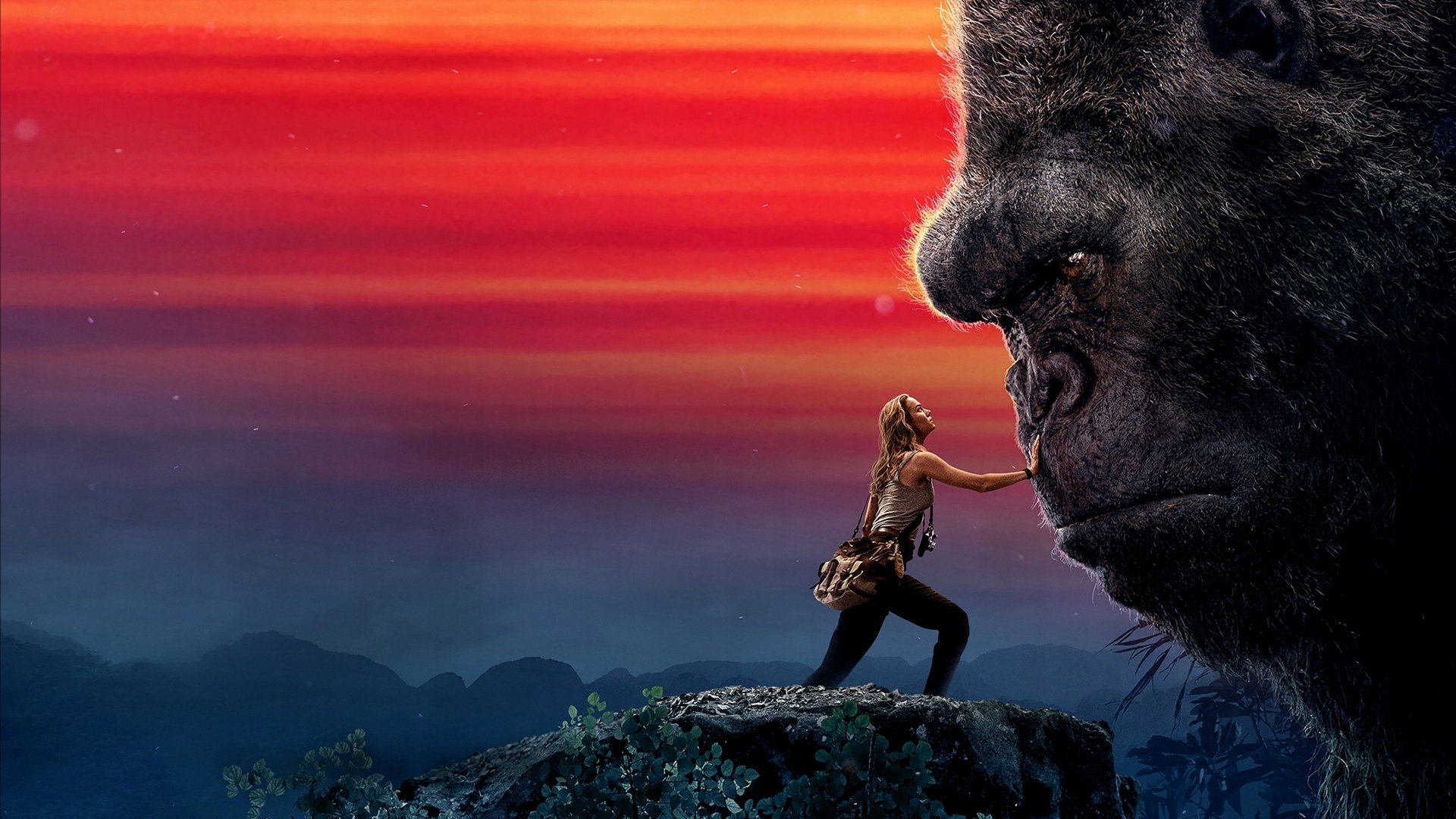 HD desktop wallpaper featuring a scene from the movie Kong: Skull Island with a large gorilla, King Kong, and a brave human character played by Brie Larson against a stunning sunset background.