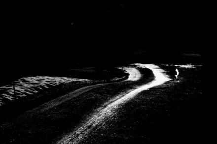 Black and white 4K Ultra HD photo of a winding road at night, showcasing high contrast and dramatic shadows, designed as a PC desktop wallpaper and background.