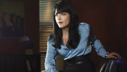HD desktop wallpaper of a dark-haired woman in a blue blouse leaning on a chair in a dim office, styled like a promotional TV drama image for Anger Management.
