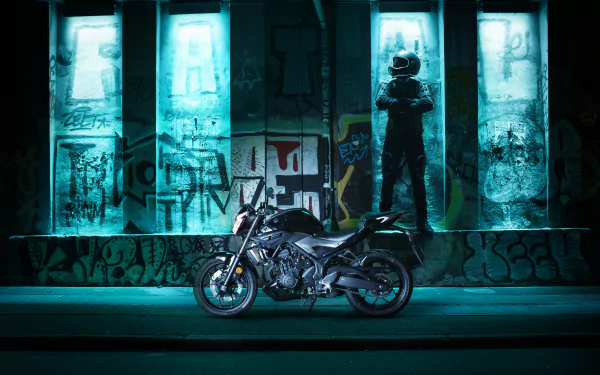 A Yamaha MT-03 motorcycle is showcased against a graffiti-covered wall with illuminated panels, captured in 4K Ultra HD as a striking PC desktop wallpaper and background.