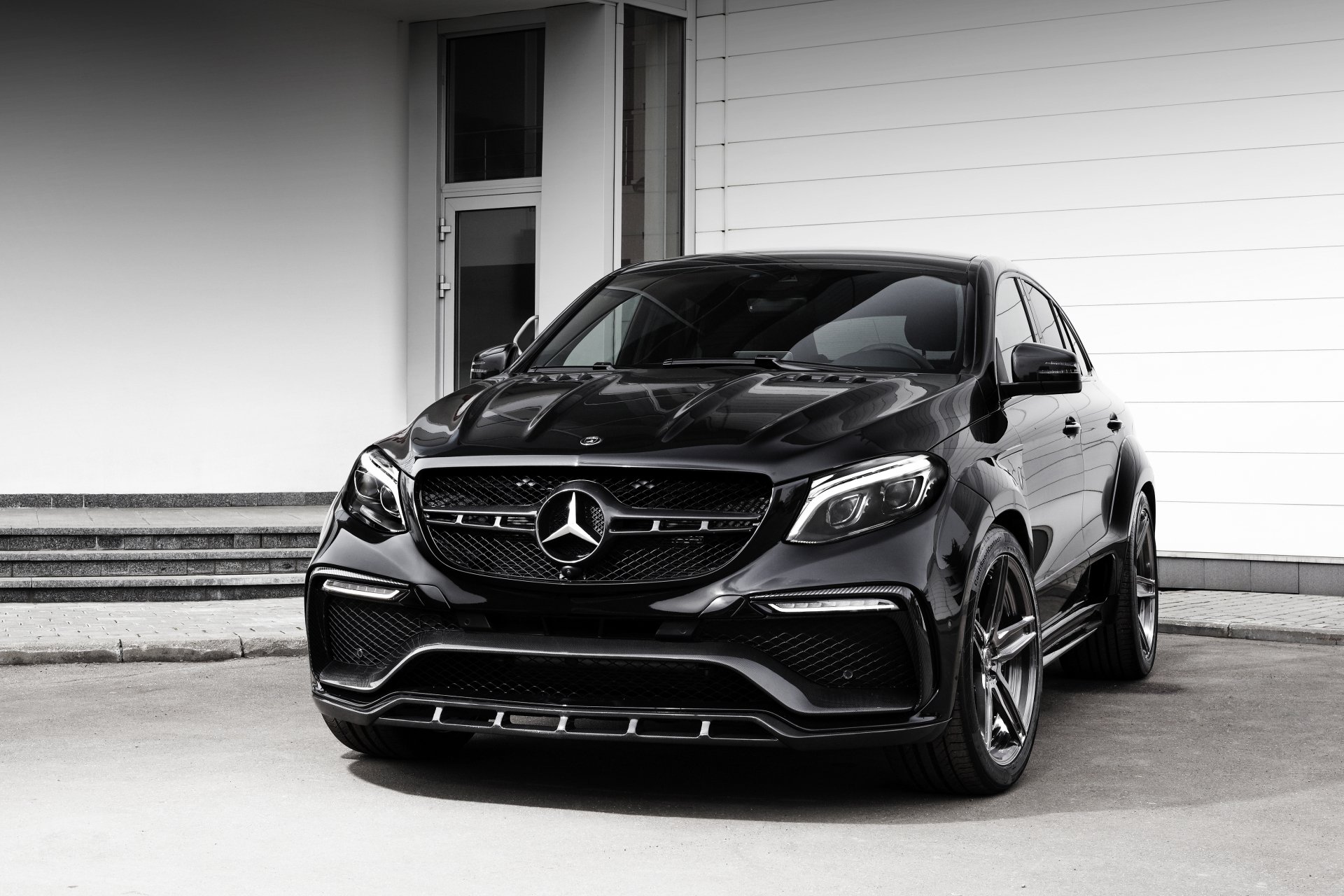 Black Mercedes-Benz GL-Class SUV parked before a white wall, luxury black car in a high-contrast 4K Ultra HD PC desktop wallpaper and background.