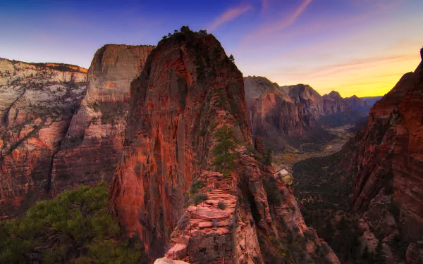 Zion National Park canyon at sunset in Utah, dramatic red cliffs and a rugged ridgeline overlooking a valley — HD desktop wallpaper background showcasing canyon nature.