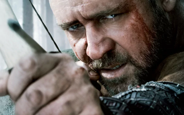 Close-up of Russell Crowe as Robin Hood from the 2010 movie, aiming a bow and arrow with intense focus in this HD PC desktop wallpaper.