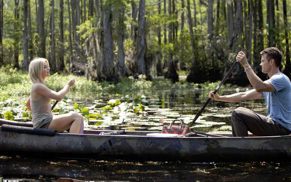 HD wallpaper of Julianne Hough and Josh Duhamel canoeing in a serene forest lake scene from the movie Safe Haven.