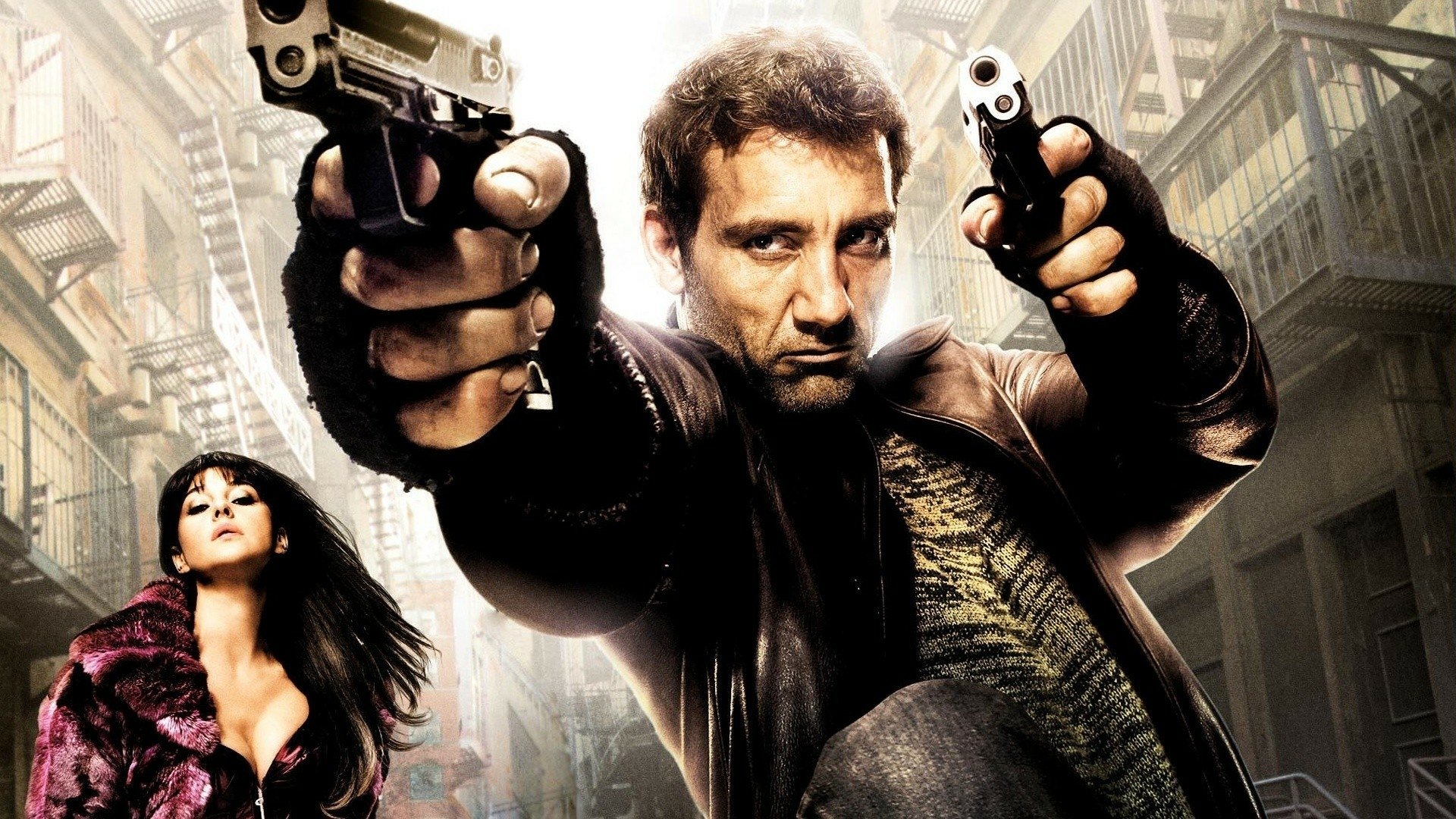 HD desktop wallpaper featuring Clive Owen and Monica Bellucci from the movie Shoot 'Em Up, with Owen aiming dual guns in an intense urban scene.