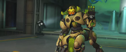 HD PC desktop wallpaper of Orisa from Overwatch: armored green-and-gold omnic guardian in a hangar, raising a hand with a weapon at her side, video game artwork background.