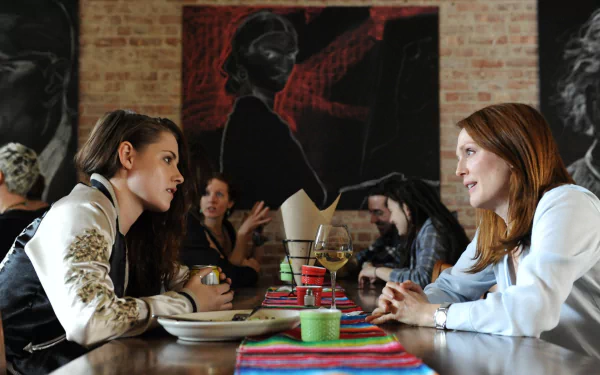 HD desktop wallpaper featuring Kristen Stewart and Julianne Moore in a scene from the movie Still Alice, engaged in conversation at a table in a cozy setting.