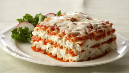 HD PC desktop wallpaper featuring a close-up of a layered lasagna meal with melted cheese and tomato sauce, garnished with fresh greens on a white plate.