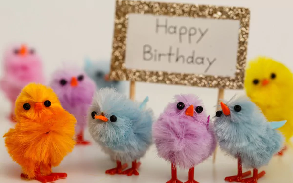 HD desktop wallpaper featuring colorful, fluffy chicks gathered around a glittery sign that reads Happy Birthday, creating a festive holiday atmosphere.