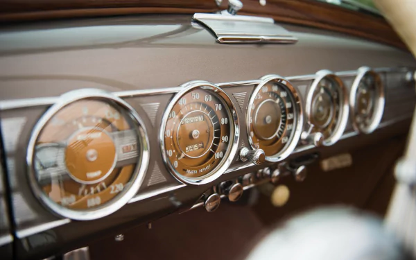 HD wallpaper featuring close-up of a classic car dashboard with elegant gauges, suitable as a desktop background.