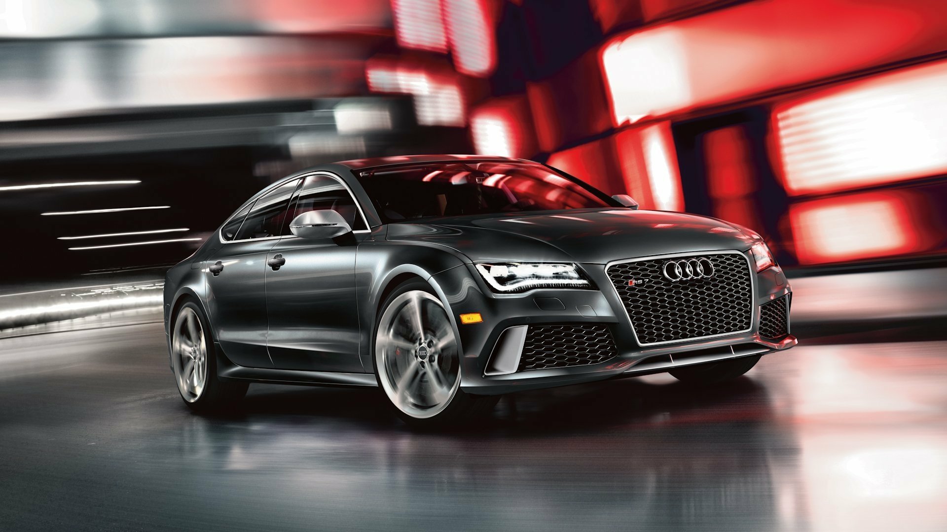 HD desktop wallpaper featuring a sleek silver Audi RS7 car in a dynamic urban setting with blurred red and white lights.