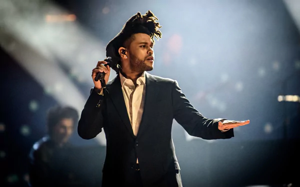 HD desktop wallpaper featuring The Weeknd performing on stage with dynamic lighting effects.