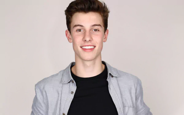 HD desktop wallpaper featuring a smiling person with a grey jacket over a black shirt, providing a simplistic and focused background.