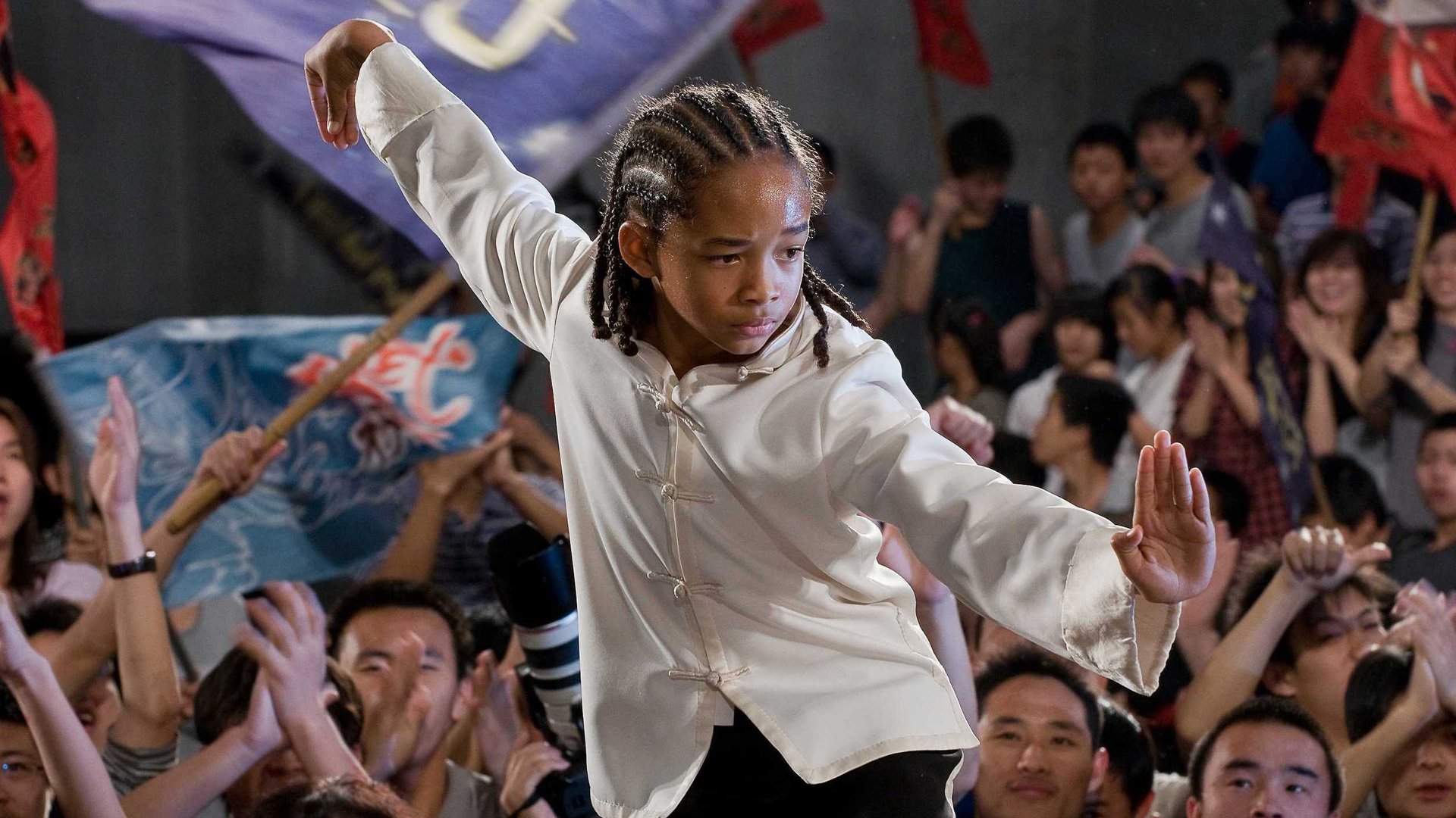 HD desktop wallpaper featuring Jaden Smith in a martial arts pose from the 2010 movie The Karate Kid, set against a lively crowd background.
