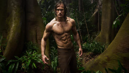 HD PC desktop wallpaper featuring Alexander Skarsgård as Tarzan in the movie The Legend of Tarzan, standing shirtless amidst a dense jungle.