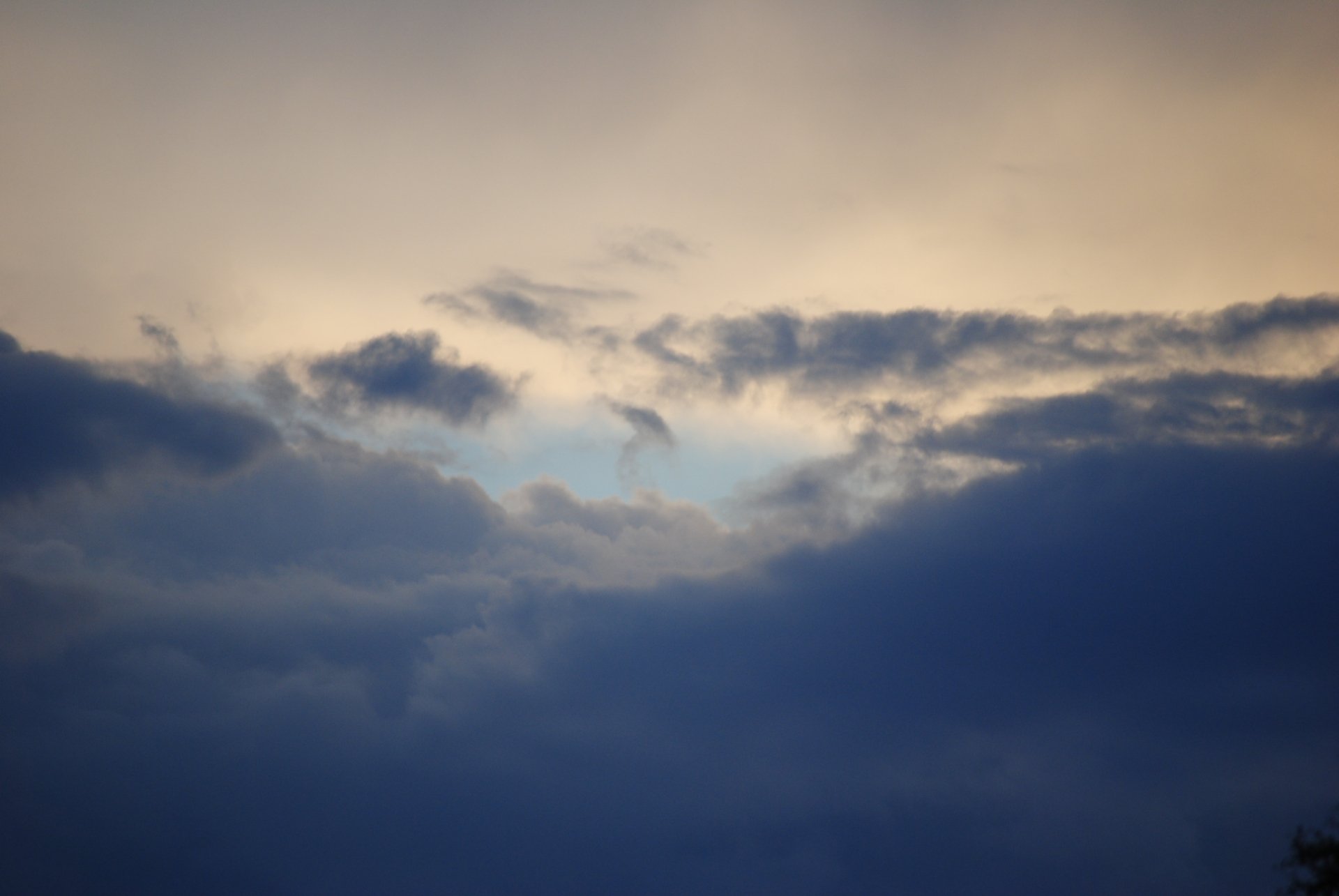 A breathtaking HD wallpaper featuring a dynamic cloudscape with varying shades of gray and hints of blue peeking through, capturing the serene beauty of nature.