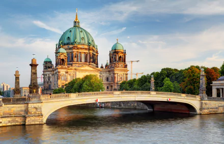 4K Ultra HD image of Berlin Cathedral with its iconic dome beside a river, framed by a bridge showcasing Germany’s historic religious architecture.