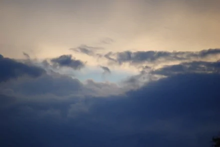 A breathtaking HD wallpaper featuring a dynamic cloudscape with varying shades of gray and hints of blue peeking through, capturing the serene beauty of nature.