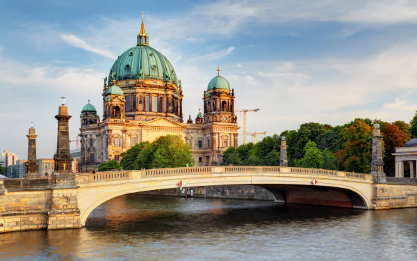 4K Ultra HD image of Berlin Cathedral with its iconic dome beside a river, framed by a bridge showcasing Germany’s historic religious architecture.