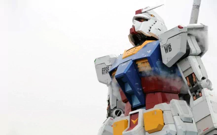 A high-definition wallpaper featuring a massive Gundam robot, showcasing detailed design and vibrant colors from the iconic anime series, set against a cloudy backdrop.