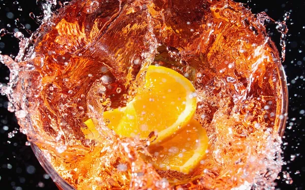 A vibrant HD desktop wallpaper featuring splashes of liquid with lemon slices, creating an energetic and refreshing food-themed background.