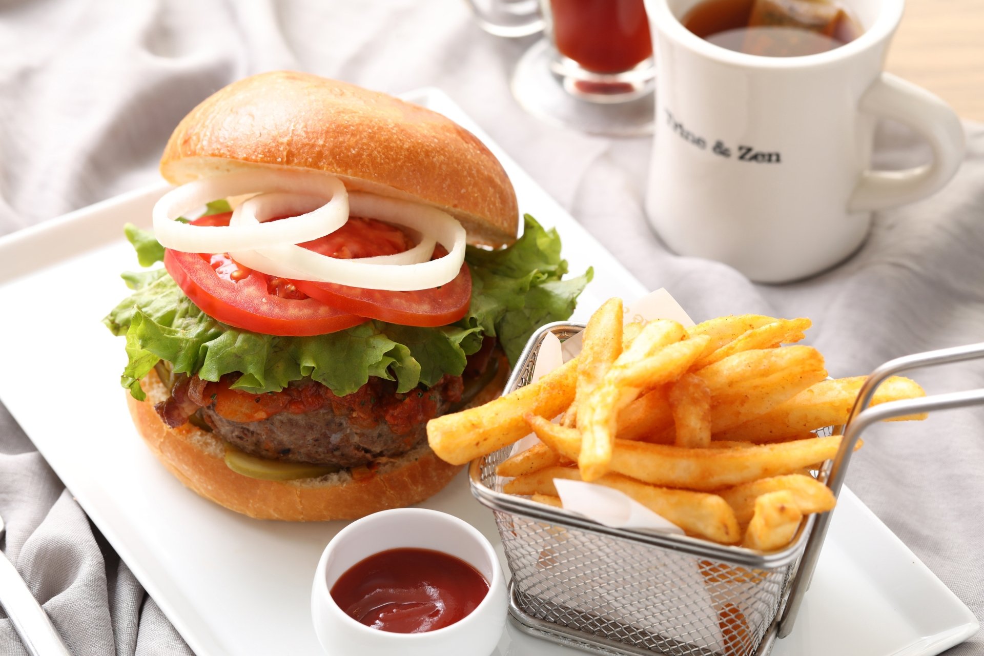HD PC desktop wallpaper featuring a close-up of a fresh burger with lettuce, tomato, onion, and a side of golden French fries with ketchup.