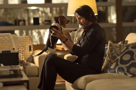Keanu Reeves as John Wick gently holds a small dog in a warm, dimly lit living room, captured in a 4K Ultra HD movie wallpaper scene.