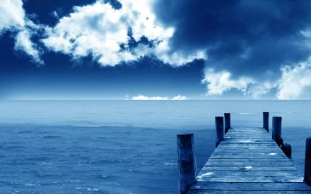 HD desktop wallpaper showcasing a wooden pier extending into the calm ocean under a dramatic HDR sky with clouds on the horizon over the water.