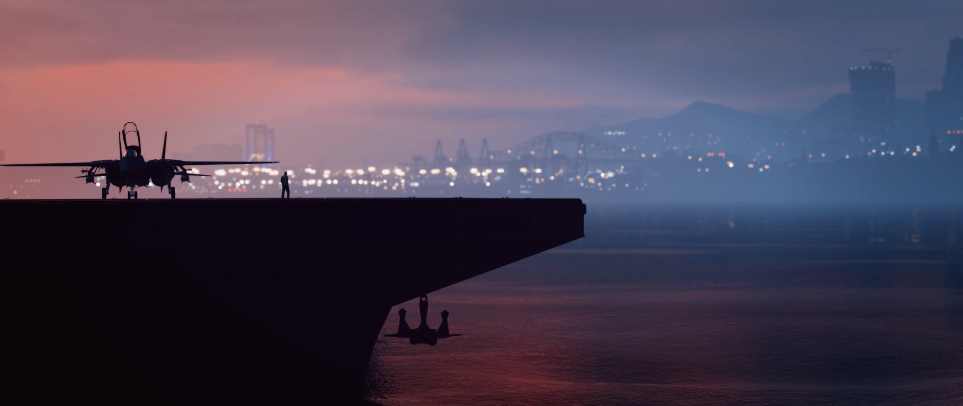Silhouette of an aircraft carrier deck with a jet fighter at sunset and a misty city skyline beyond — Grand Theft Auto V 4K Ultra HD PC desktop wallpaper.