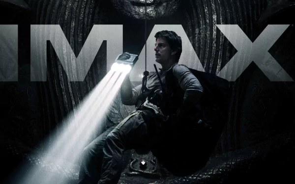 Tom Cruise in a dramatic scene from the movie The Mummy (2017), illuminated by a flashlight in a dark, cavernous setting, with IMAX branding in the background. HD desktop wallpaper and background.
