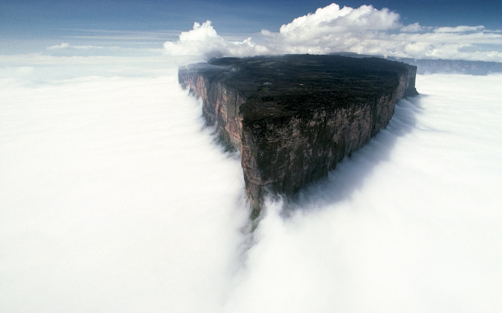 Majestic mountain peak enveloped in clouds.