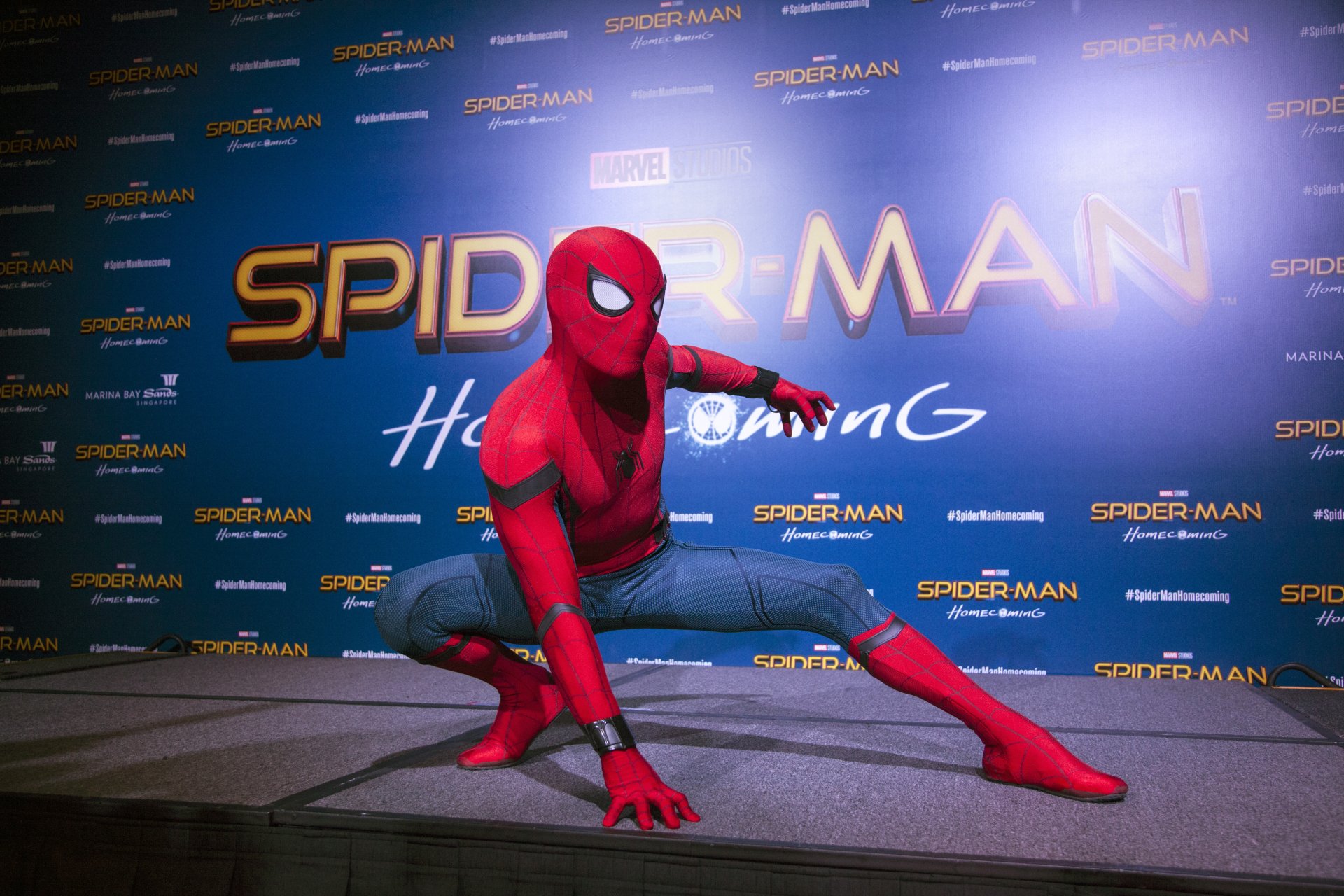 HD wallpaper featuring Spider-Man in his iconic suit from the movie Spider-Man: Homecoming, against a background with the movie's title and logos.