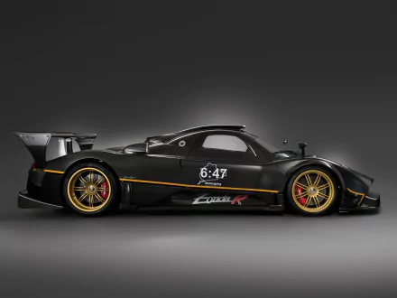 HD desktop wallpaper featuring a sleek black Pagani Zonda R supercar with gold accents, showcasing its aerodynamic design and performance-oriented details.