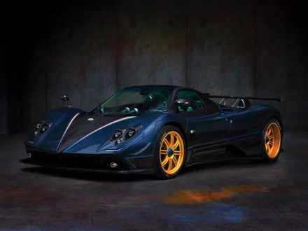 HD wallpaper of a dark blue Pagani Zonda Tricolore supercar with bright orange wheels, showcased against a textured dark background.