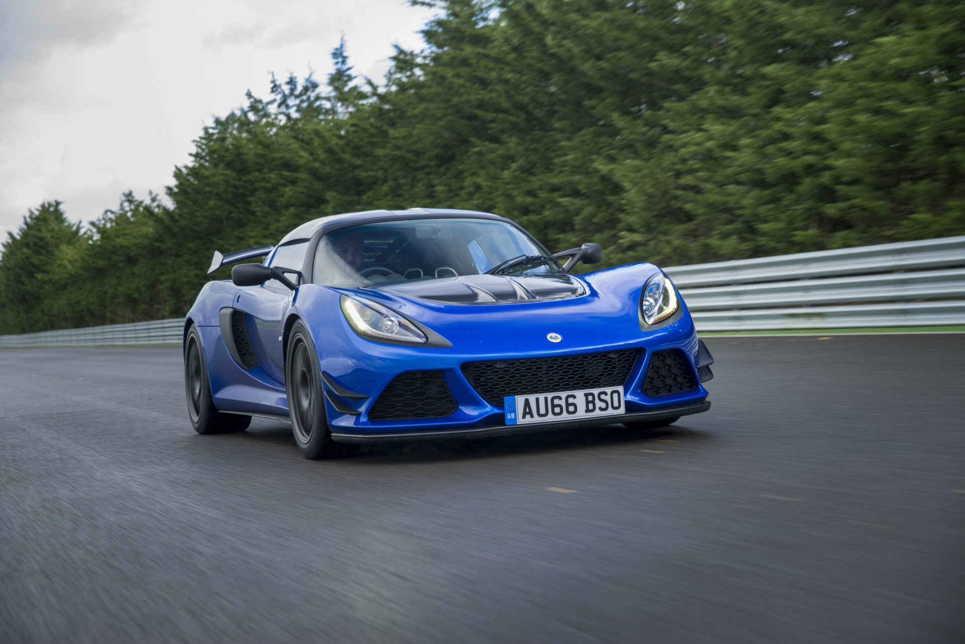 Blue Lotus Exige supercar on a racetrack — 2K Quad HD PC desktop wallpaper/background featuring a Lotus car vehicle.