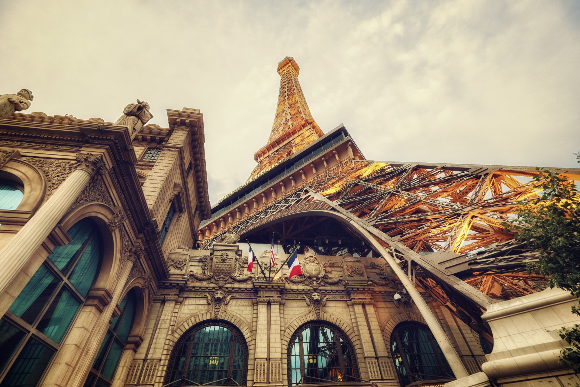 HD desktop wallpaper of the Eiffel Tower replica in Las Vegas, showcasing the intricate architecture and vibrant atmosphere under a cloudy sky.
