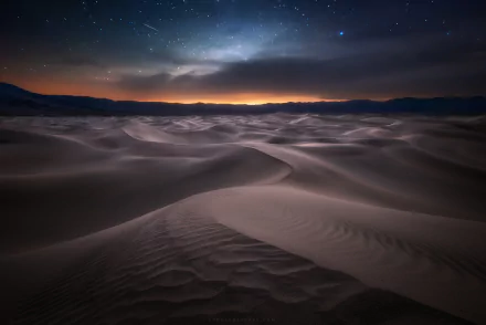 A serene night in Death Valley, California, featuring starry skies over sweeping sand dunes, capturing the beauty of nature in this desert landscape.