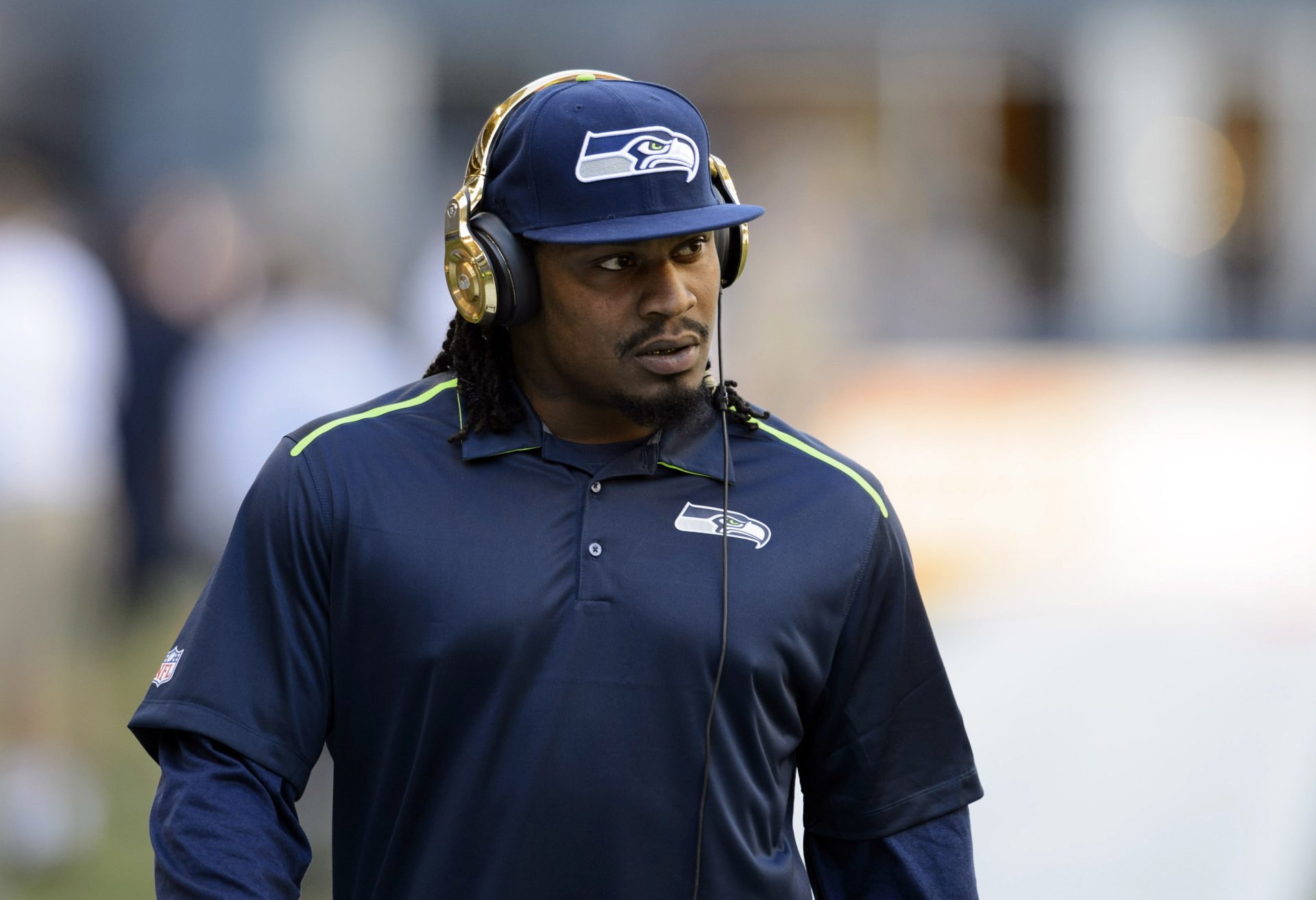 Marshawn Lynch, in Seattle Seahawks gear, features on an HD desktop wallpaper with a sports theme.