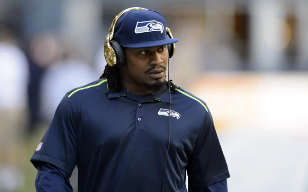 Marshawn Lynch, in Seattle Seahawks gear, features on an HD desktop wallpaper with a sports theme.