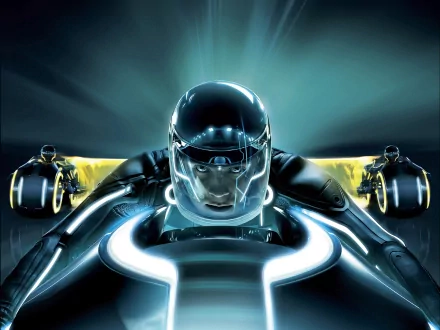 A dynamic HD wallpaper from *TRON: Legacy*, featuring a futuristic character in a sleek suit, racing forward with vivid light trails and a high-tech backdrop.