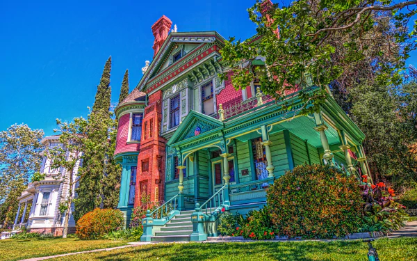 A vibrant, colorful Victorian house captured in HDR quality, showcasing intricate architectural details and lush surrounding greenery in a 4K Ultra HD desktop wallpaper.