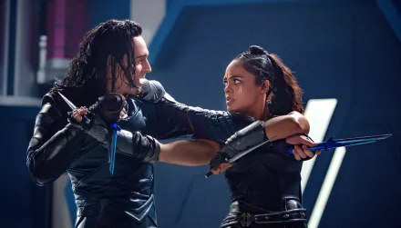 Tessa Thompson and Tom Hiddleston as Valkyrie and Loki from Marvel's Thor: Ragnarok engage in a tense battle scene. HD desktop wallpaper featuring characters from the movie.