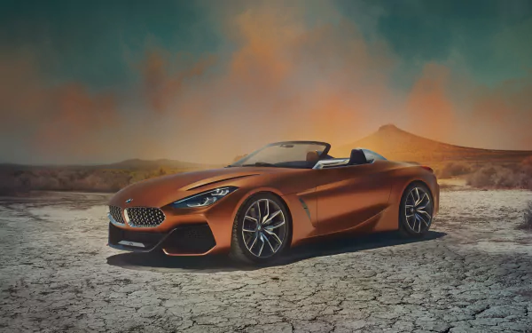 5K Ultra HD desktop wallpaper of an orange BMW Z4 convertible parked on cracked desert floor beneath a dramatic sky.